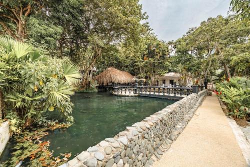 a river with a stone wall next to a house at Hotel Quimbaya in San Jerónimo