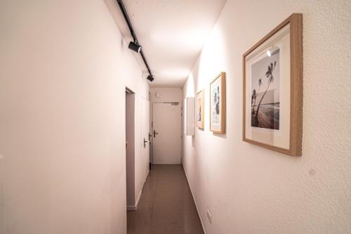 a hallway with white walls and pictures on the walls at Sun Passion Condo in Marigot