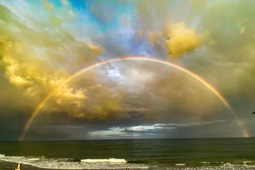 un arco iris en un cielo nublado sobre el océano en 2007 S Ocean Blvd, 0406 - Ocean Front Sleeps 10, en Myrtle Beach