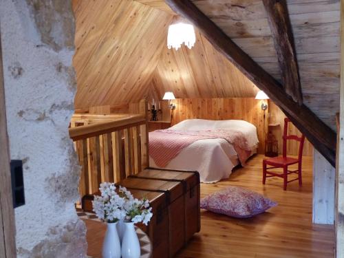 a bedroom with a bed in a wooden attic at La Biroussanne in Agert