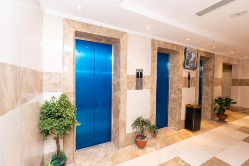 a blue door in a lobby with plants at Burj Al Balad Hotel in Mecca