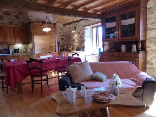 a living room with a table and a dining room at La Biroussanne in Agert