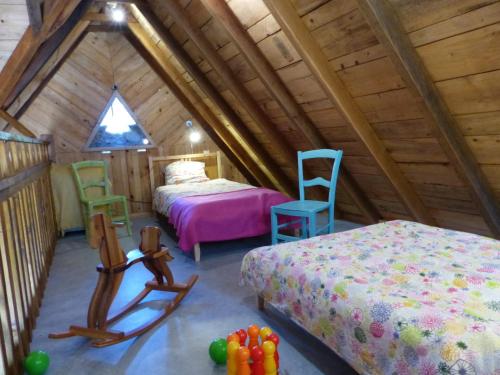 a room with two beds and two chairs in a attic at La Biroussanne in Agert