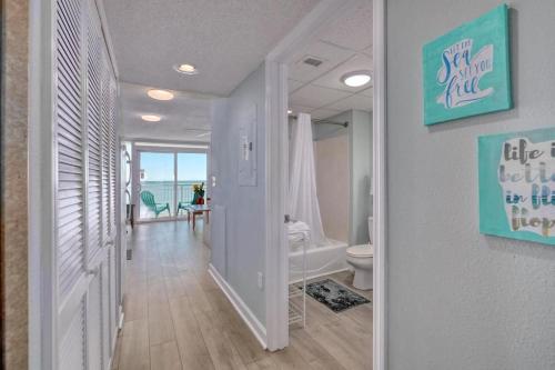 a hallway with a bathroom with a tub and a toilet at 2501 S Ocean Blvd, 0407 - Ocean Front Sleeps 6 in Myrtle Beach