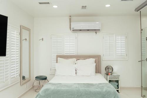 a bedroom with white walls and a bed with white pillows at Luxury Lofts With Private Pool in Ciudad Juárez