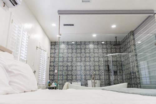 a bedroom with a shower and a white bed at Luxury Lofts With Private Pool in Ciudad Juárez