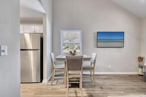 a kitchen with a table with chairs and a refrigerator at 1408 Perrin Dr, Unit D - Ocean Walk Sleeps 8 in Myrtle Beach