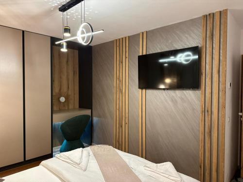 a bedroom with a bed and a tv on the wall at Apartament de Lux André in Sibiu