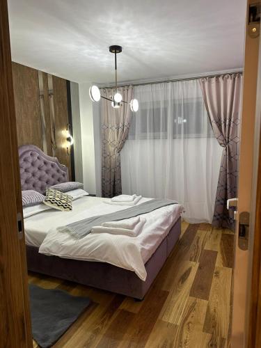 a bedroom with a large bed and a window at Apartament de Lux André in Sibiu