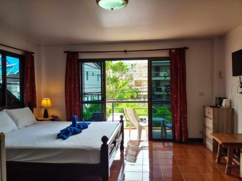 1 dormitorio con 1 cama y puerta corredera de cristal en Kata Lina guesthouse, en Kata Beach