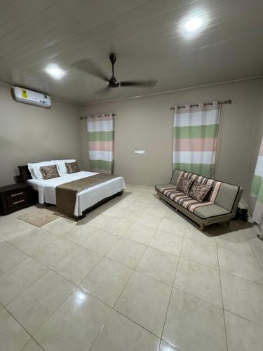 a bedroom with a bed and a couch in it at Calm Hillside Swimming Pool Villa Apartment in Accra