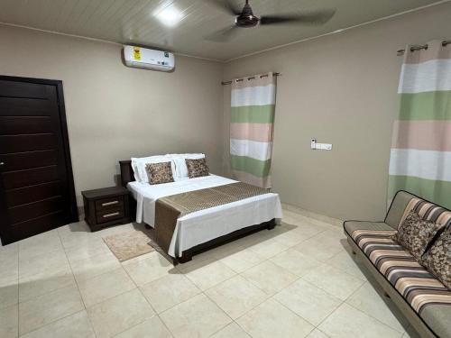 a bedroom with a bed and a couch at Calm Hillside Swimming Pool Villa Apartment in Accra