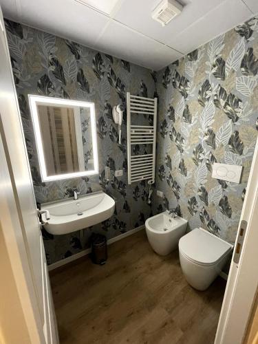 a bathroom with a sink and a toilet and a mirror at ROME'S GLORIA HOTEL in Rome
