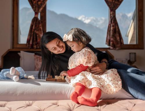 a woman and a little girl playing chess on a bed at The Wooden Chalet, Manali by DBP in Manāli