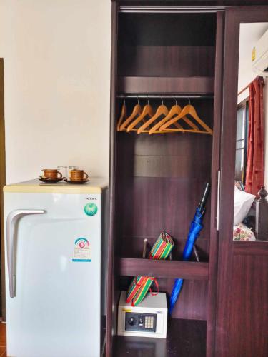a kitchen with a refrigerator and a shelf with pens at Kata Lina guesthouse in Kata Beach