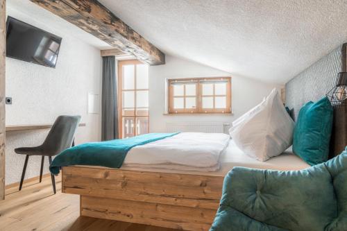 ein Schlafzimmer mit einem Bett, einem Stuhl und einem TV in der Unterkunft Ferienwohnung Reicherhof in Sankt Veit im Pongau