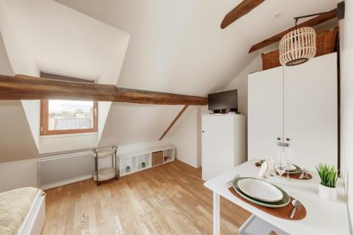 Cette chambre blanche comprend un bureau et un lit. dans l'établissement Élégance à la Versailles, à Versailles