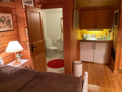 a bedroom with a bed and a bathroom with a sink at Timrad stuga i kanten av skogen med SPA möjlighet in Mullsjö