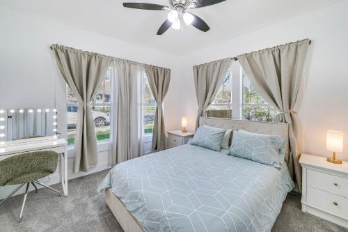 a bedroom with a bed with a ceiling fan and windows at Charming San Antonio Home about 2 Mi to The Alamo! in San Antonio