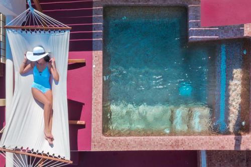 a woman sitting on a hammock next to a swimming pool at Luxury Villas Hariton in Emporio