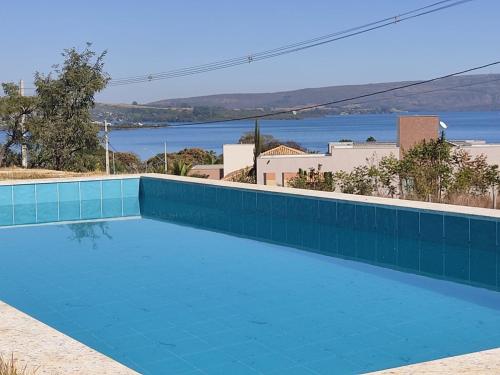 uma piscina azul com vista para a água em Casa Brisas do Lago em Capitólio