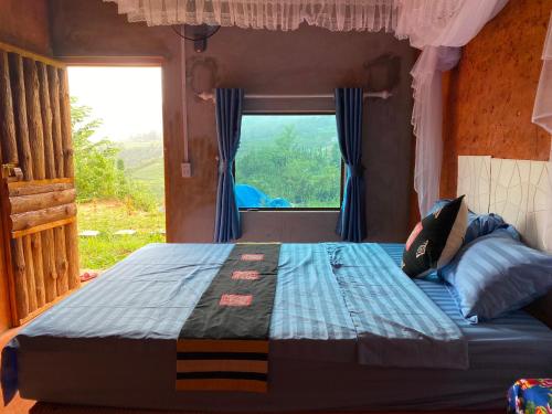 een slaapkamer met een bed en een raam met uitzicht bij Ly Quoc Tuan Homestay in Quản Bạ