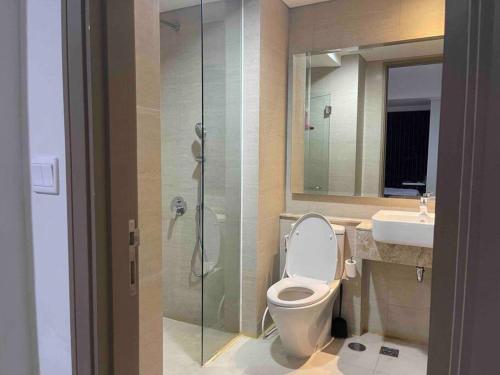 a bathroom with a toilet and a shower and a sink at Comfort One Bed Room Apartment Gold Coast PIK in Jakarta