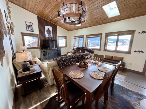 sala de estar con mesa y sofá en Ski Chalet, en Gallatin Gateway