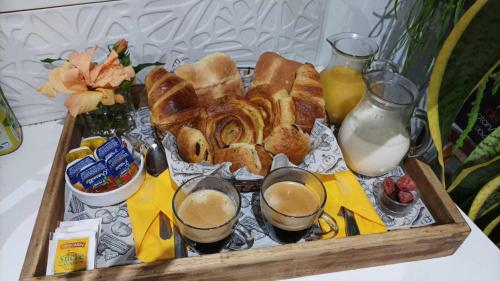 a tray of bread and drinks on a table at CAMPING le fruit de la passion in Saint-Louis