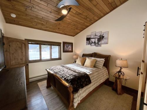 1 dormitorio con 1 cama con techo de madera en Ski Chalet, en Gallatin Gateway