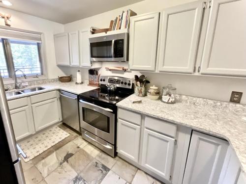 a kitchen with white cabinets and a stove top oven at Skycrest Luxury Condo, Sleeps 7 in Big Sky