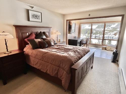 a bedroom with a large bed and a large window at Skycrest Luxury Condo, Sleeps 7 in Big Sky