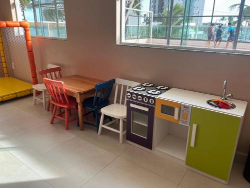 uma cozinha com um fogão de brinquedo e uma mesa em Salinas Park Resort em Salinópolis