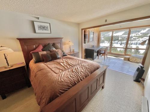 a bedroom with a large bed and a large window at Skycrest Luxury Condo, Sleeps 7 in Big Sky