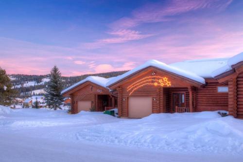 a log cabin in the snow with christmas lights on it at Last Minute Special- Cozy Log Cabin, Views, Hottub in Gallatin Gateway
