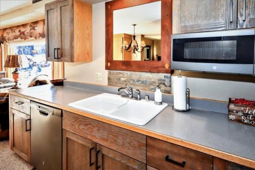 a kitchen with a sink and a microwave at Spectacular Views, Pool, Hot Tub, Mountain Village in Big Sky