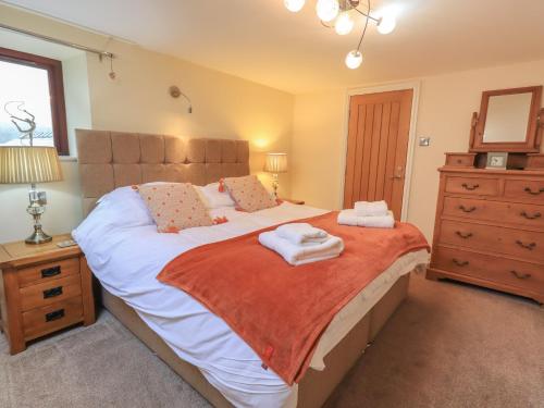 a bedroom with a large bed with towels on it at Orcaber Farm Barn in Austwick