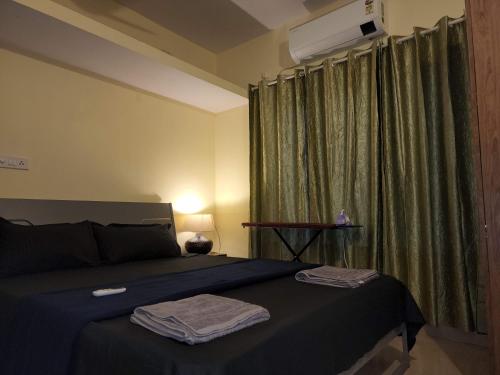 a bedroom with a bed with two towels on it at SD D'Souza Heritage Moira Flats with Reserved Parking in Moira
