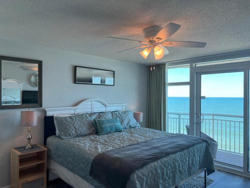 a bedroom with a bed with a ceiling fan and a balcony at 2501 S Ocean Blvd, 1101 - Ocean Front Sleeps 8 in Myrtle Beach