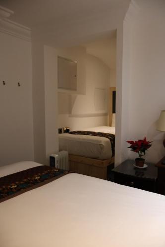 a hotel room with two beds and a table at Dreamtel London Kensington in London
