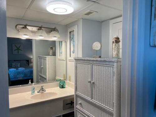 a bathroom with a sink and a mirror and a bed at 2501 S Ocean Blvd, 1101 - Ocean Front Sleeps 8 in Myrtle Beach