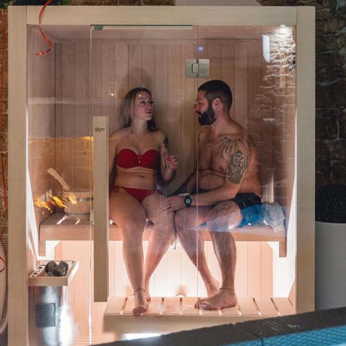 Un uomo e una donna seduti in una vasca da bagno di B&B Rhea Luxury a Terlizzi