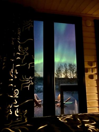 a view of the northern lights through a window at Aurora Forest Cabin in Rovaniemi