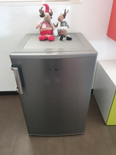 three stuffed animals sitting on top of a grey refrigerator at B&B Casa Sara in Cassano dʼAdda