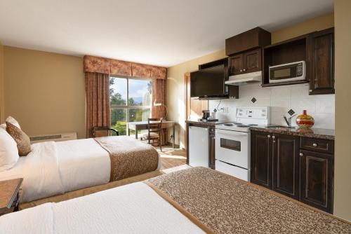 a hotel room with two beds and a kitchen at Days Inn by Wyndham Surrey in Surrey