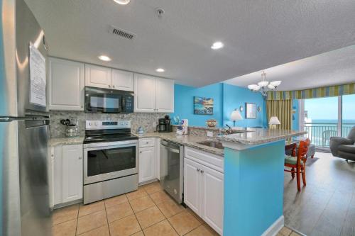a kitchen with white cabinets and a blue wall at 2501 S Ocean Blvd, 0929 - Ocean View Sleeps 8 in Myrtle Beach