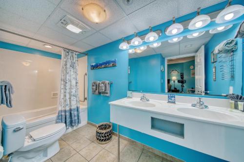 a blue bathroom with a toilet and a sink at 2501 S Ocean Blvd, 0929 - Ocean View Sleeps 8 in Myrtle Beach