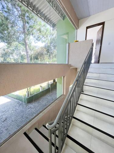 a staircase in a house with a large window at Casa de Campo Sol & Luz in Campina Grande do Sul