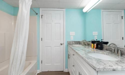 ein Badezimmer mit zwei Waschbecken und einer blauen Wand in der Unterkunft 4800 S Ocean Blvd, 0915 - Ocean Front Sleeps 6 in Myrtle Beach