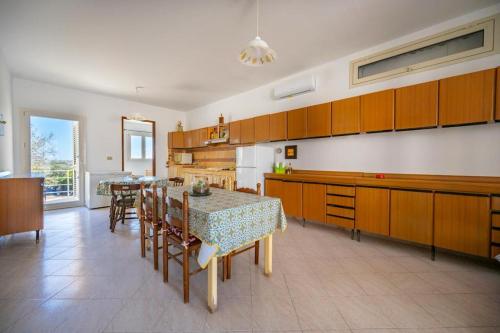 cocina con mesa y sillas y cocina con armarios en Casa Luciano, en Granelli